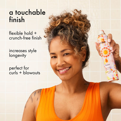 Woman holding a bottle of Amika fluxus touchable hairspray with text about its features.