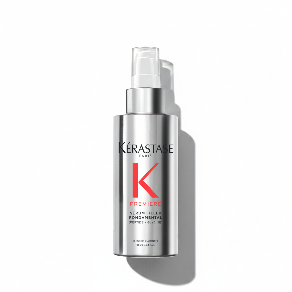 A bottle of Kérastase Première Sérum Filler Fondamental Hair Serum with a white pump and red detailing.