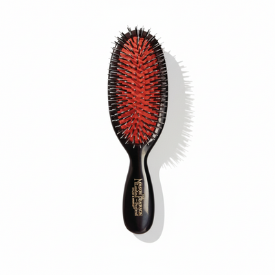 Black hairbrush with red bristles on a white background