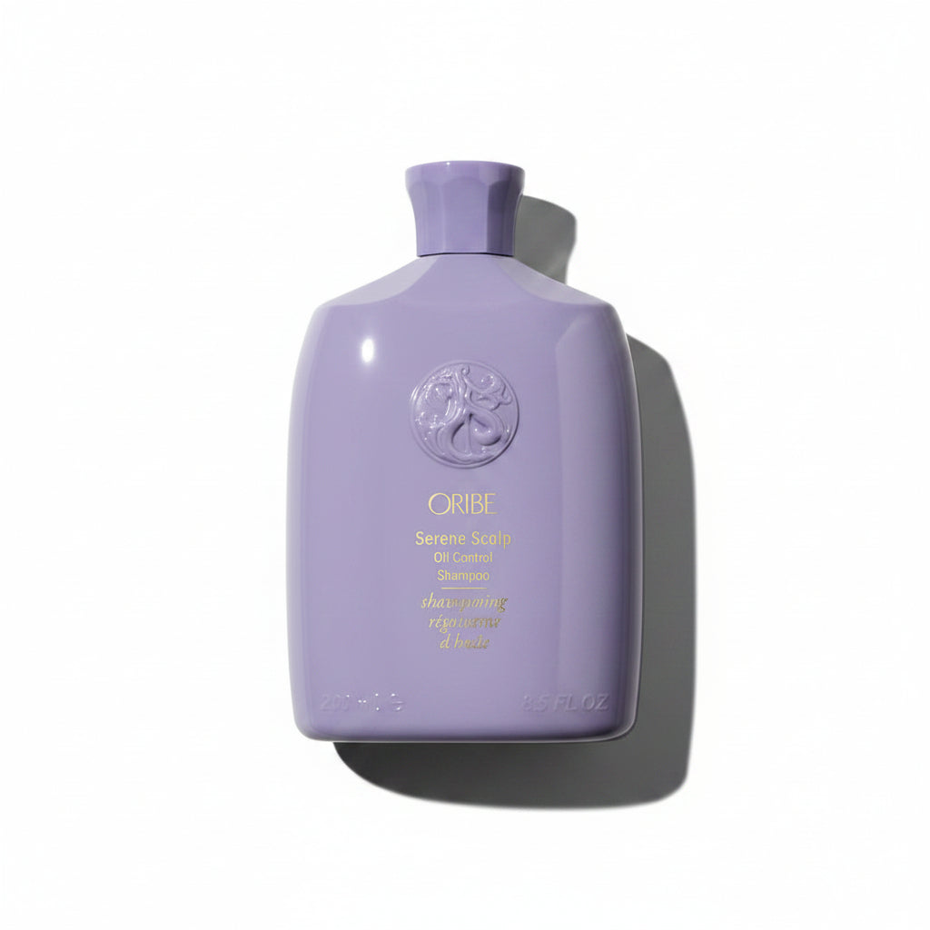A bottle of Serene Scalp Oil Control Shampoo by Oribe with a purple label and cap, displaying the brand logo and product name.