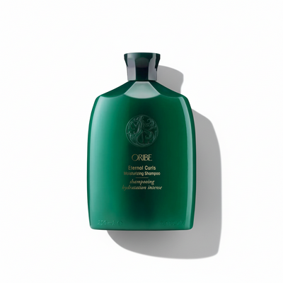 Green shampoo bottle with Oribe logo on a white background