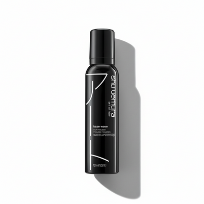 Black hair product bottle with Shu Uemura branding on a white background
